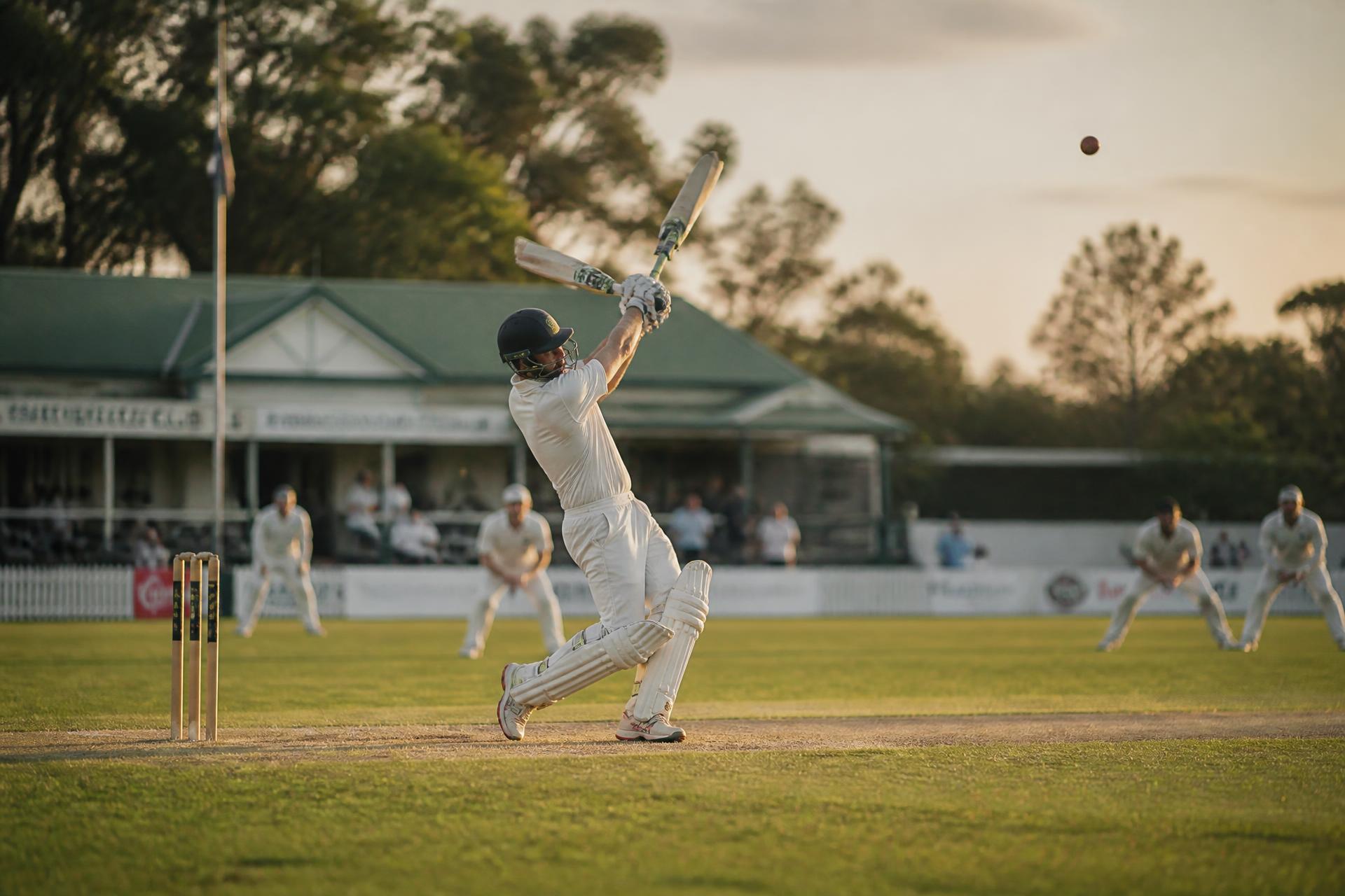 Community cricket match at golden hour on a suburban oval